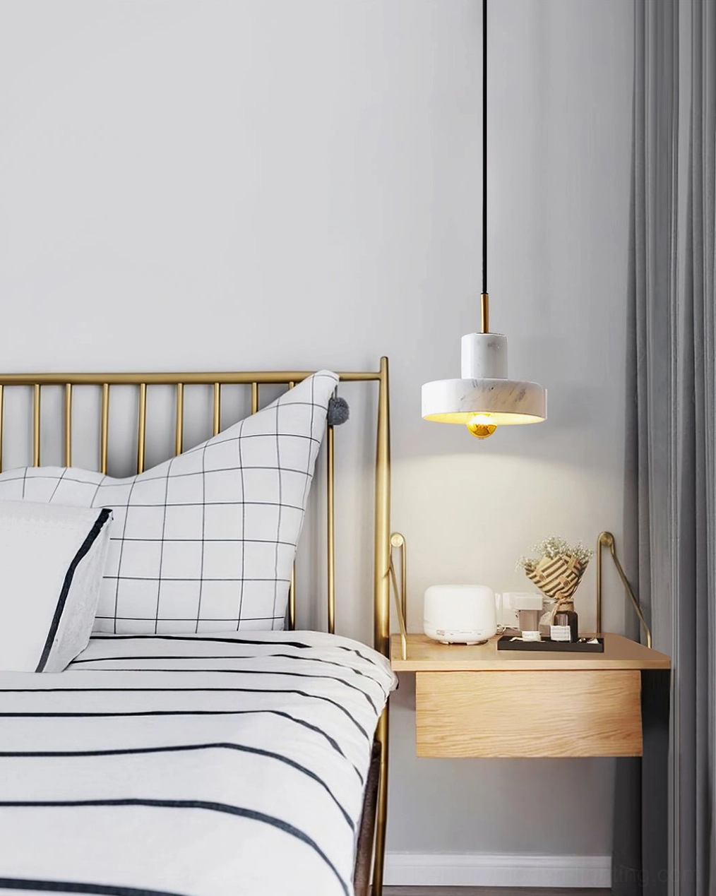 White marble pendant lamp above modern bedroom with brass bed frame, striped bedding and minimalist nightstand