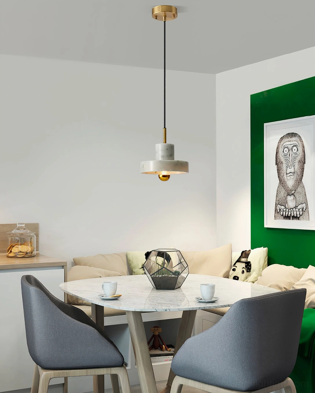 White marble pendant lamp hanging above dining table in modern dining nook with green accent wall