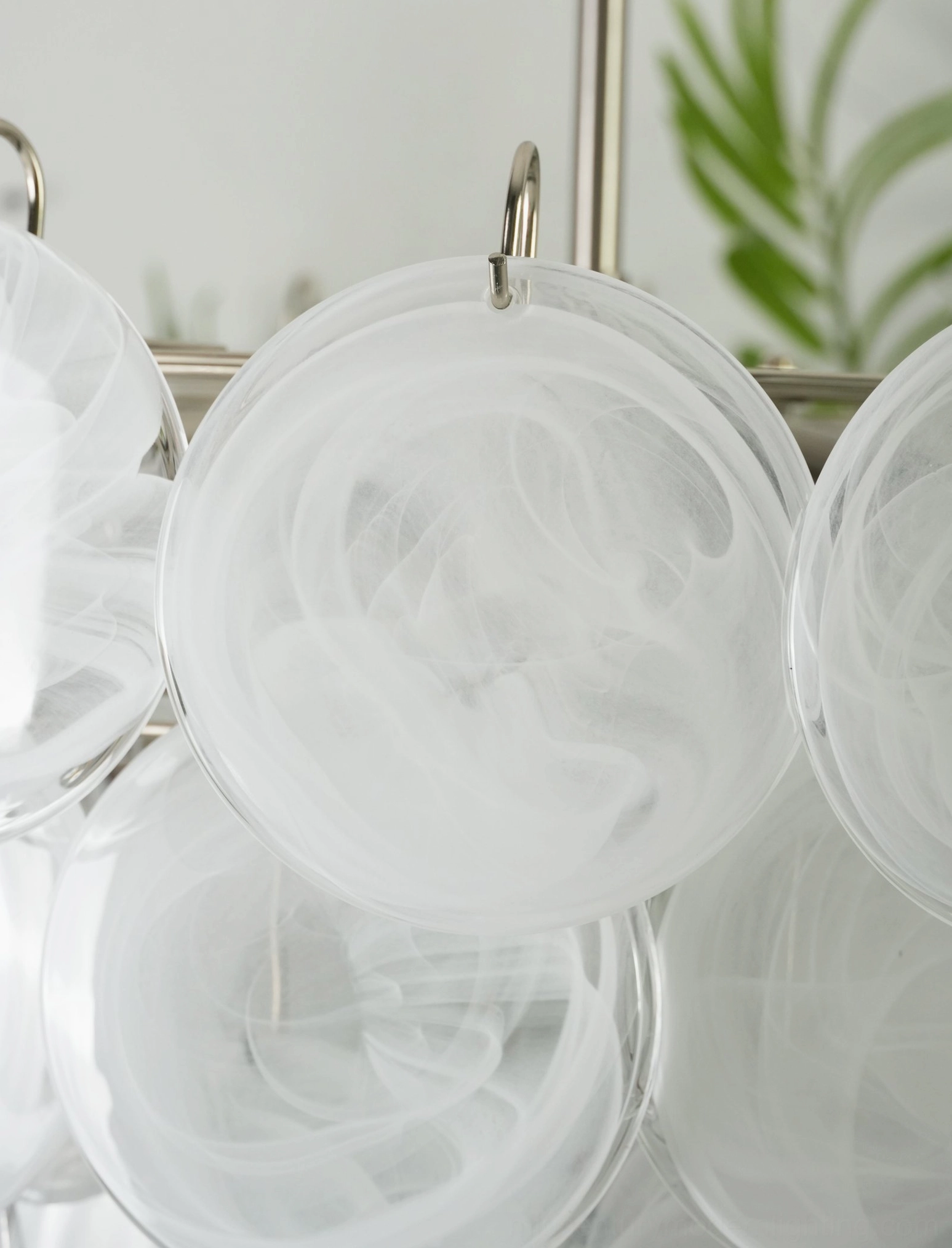 White disc chandelier with stacked translucent glass creating soft diffused light, modern minimalist home environment