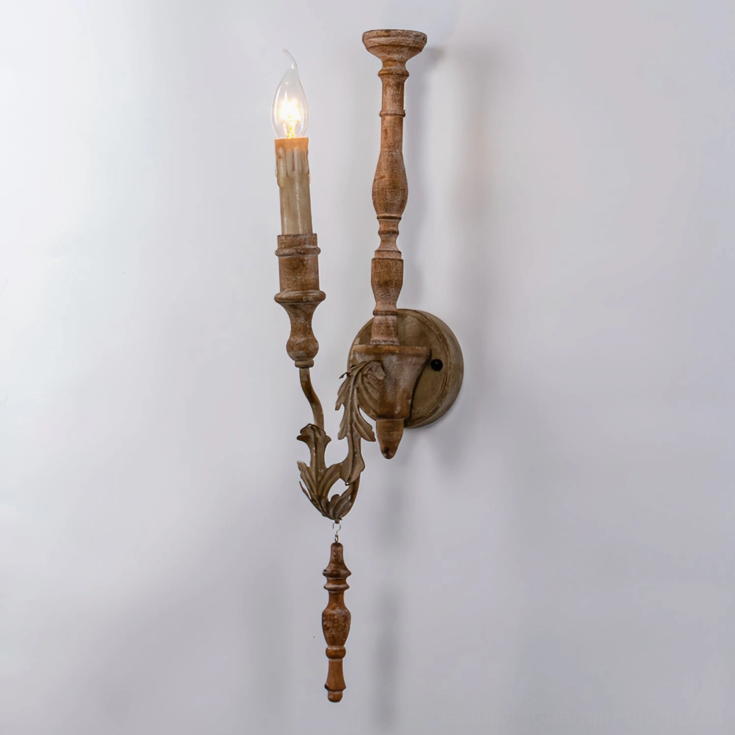 Brown rustic wall sconce with dual arms and hanging bronze carved finial, studio background