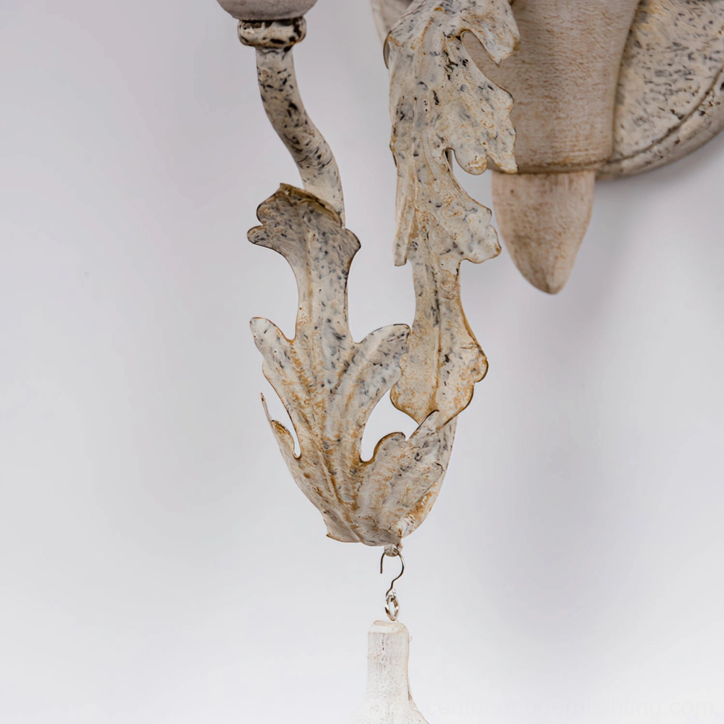 Carved metal leaf ornament detail on aged bronze wall sconce hardware