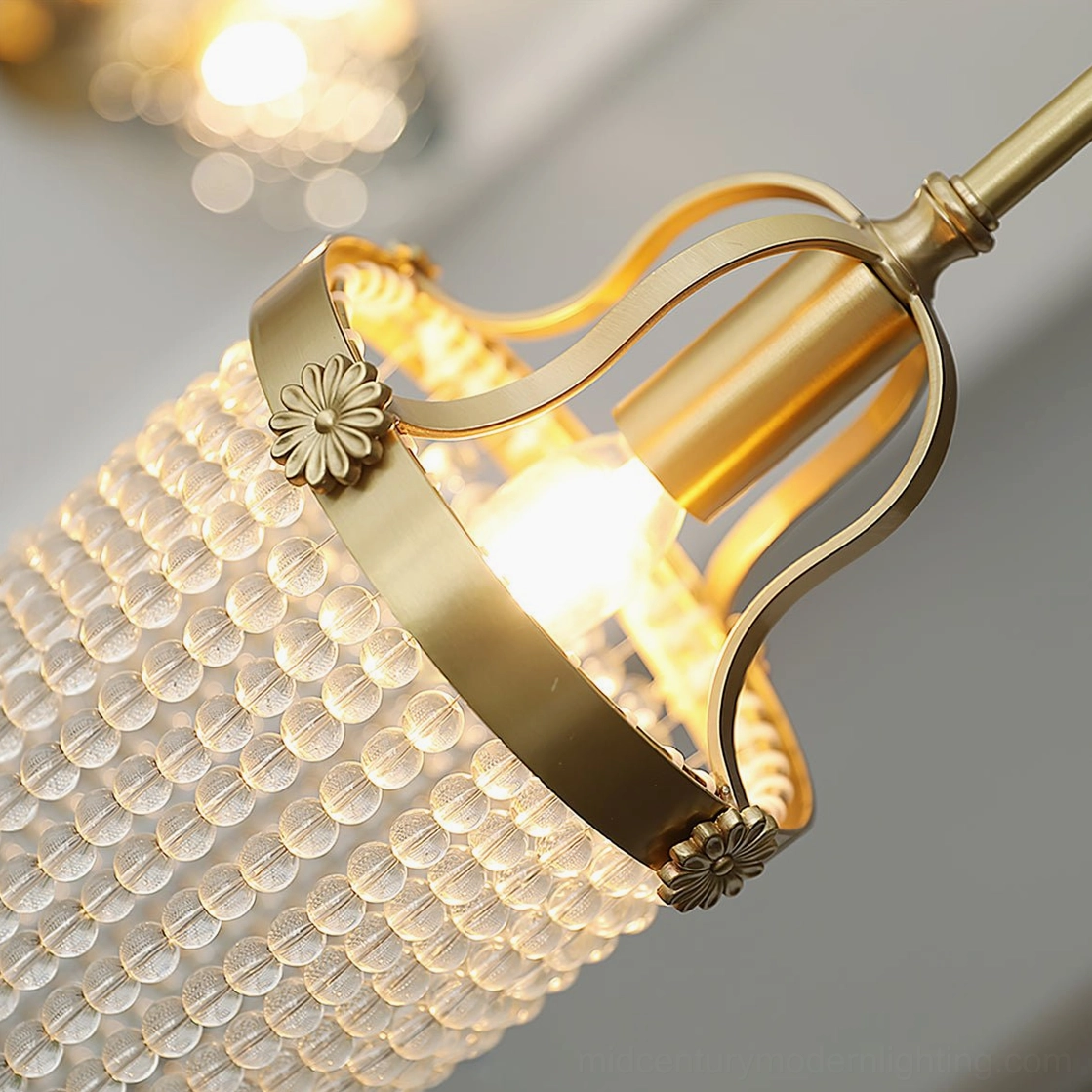 Close-up detail of Winham pendant showing flower-shaped brass accents and brushed gold metal finish from side angle
