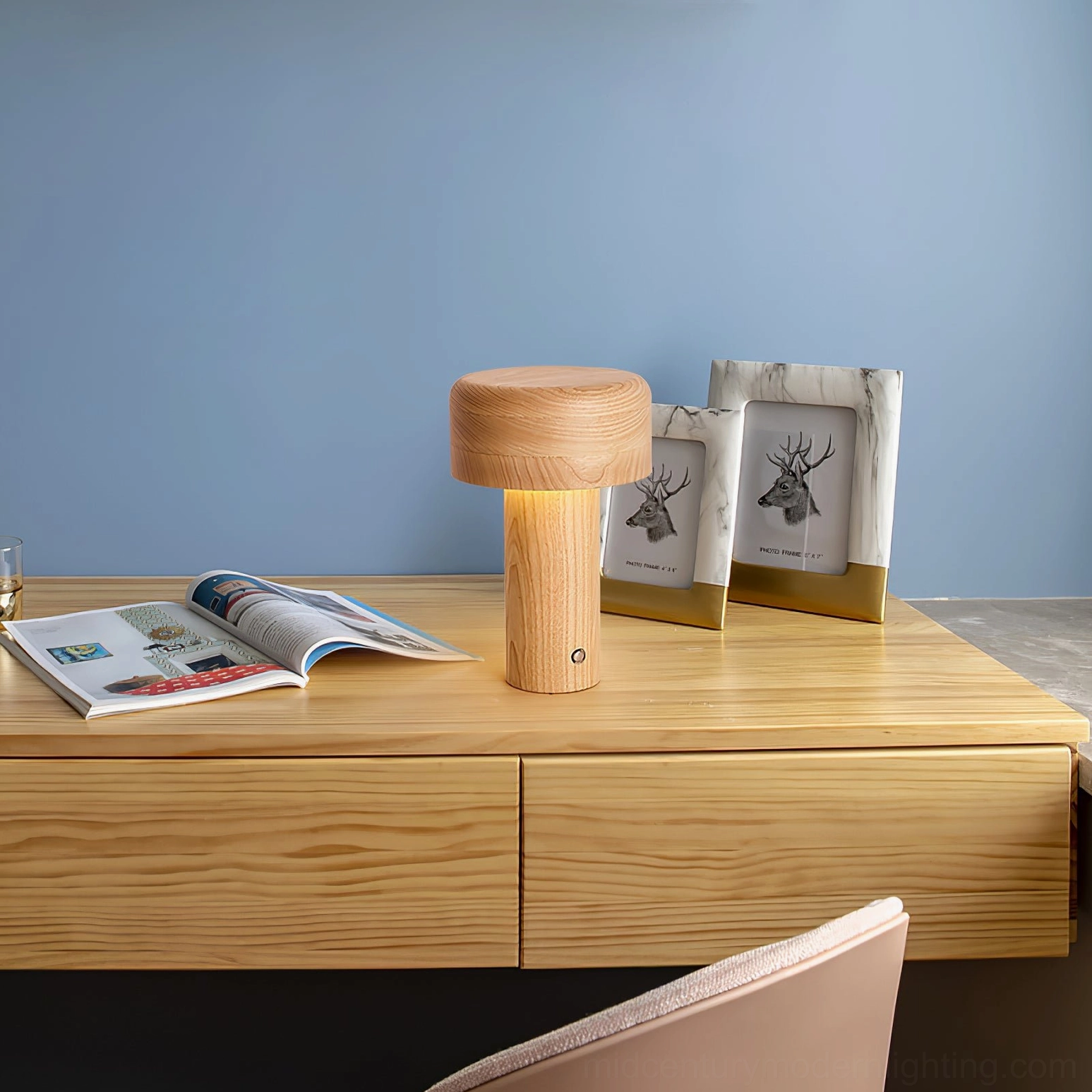 Wooden mushroom lamp on home desk paired with photo frames and magazines in nordic style