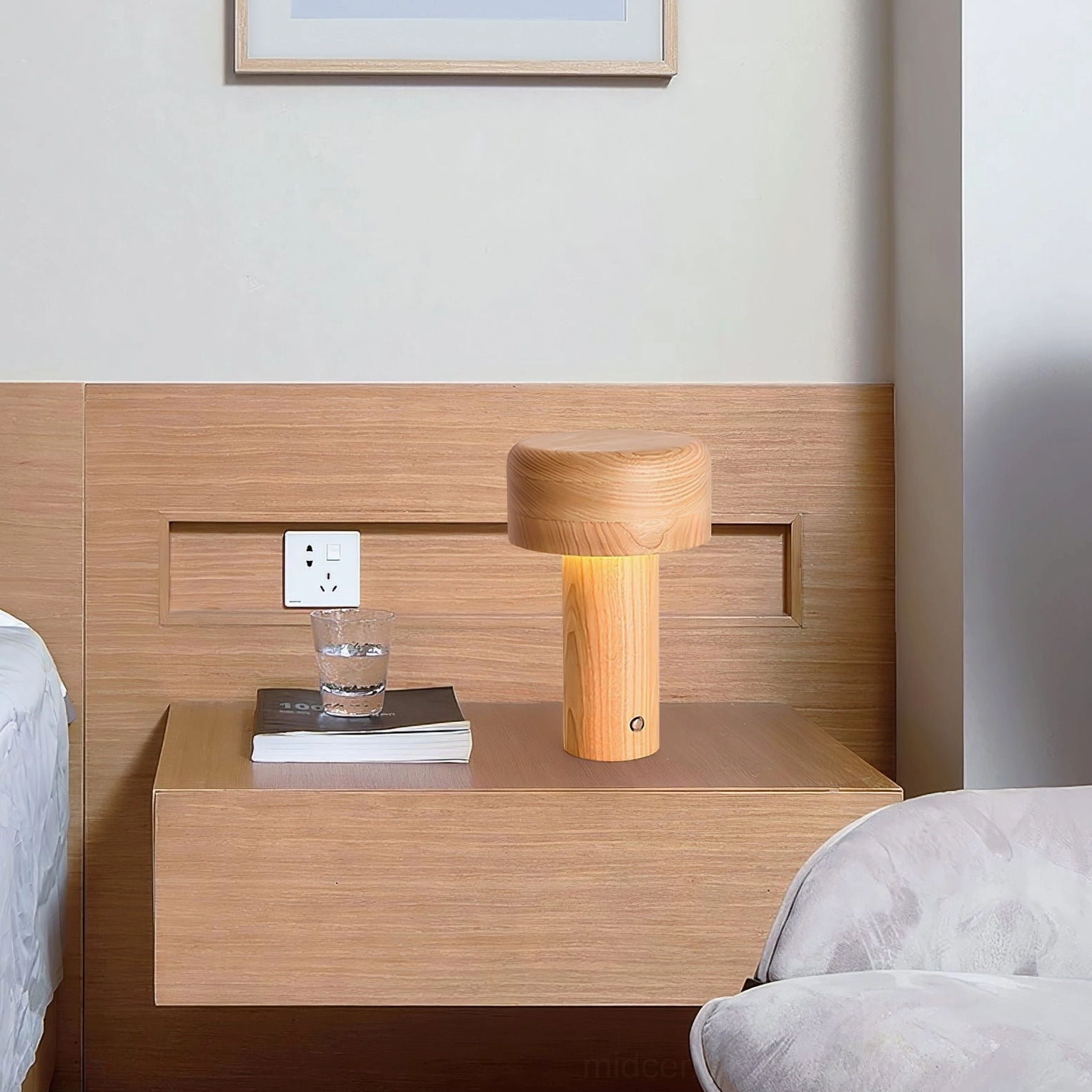 Minimalist wooden table lamp on bedside desk with glass and book, soft bedroom ambiance