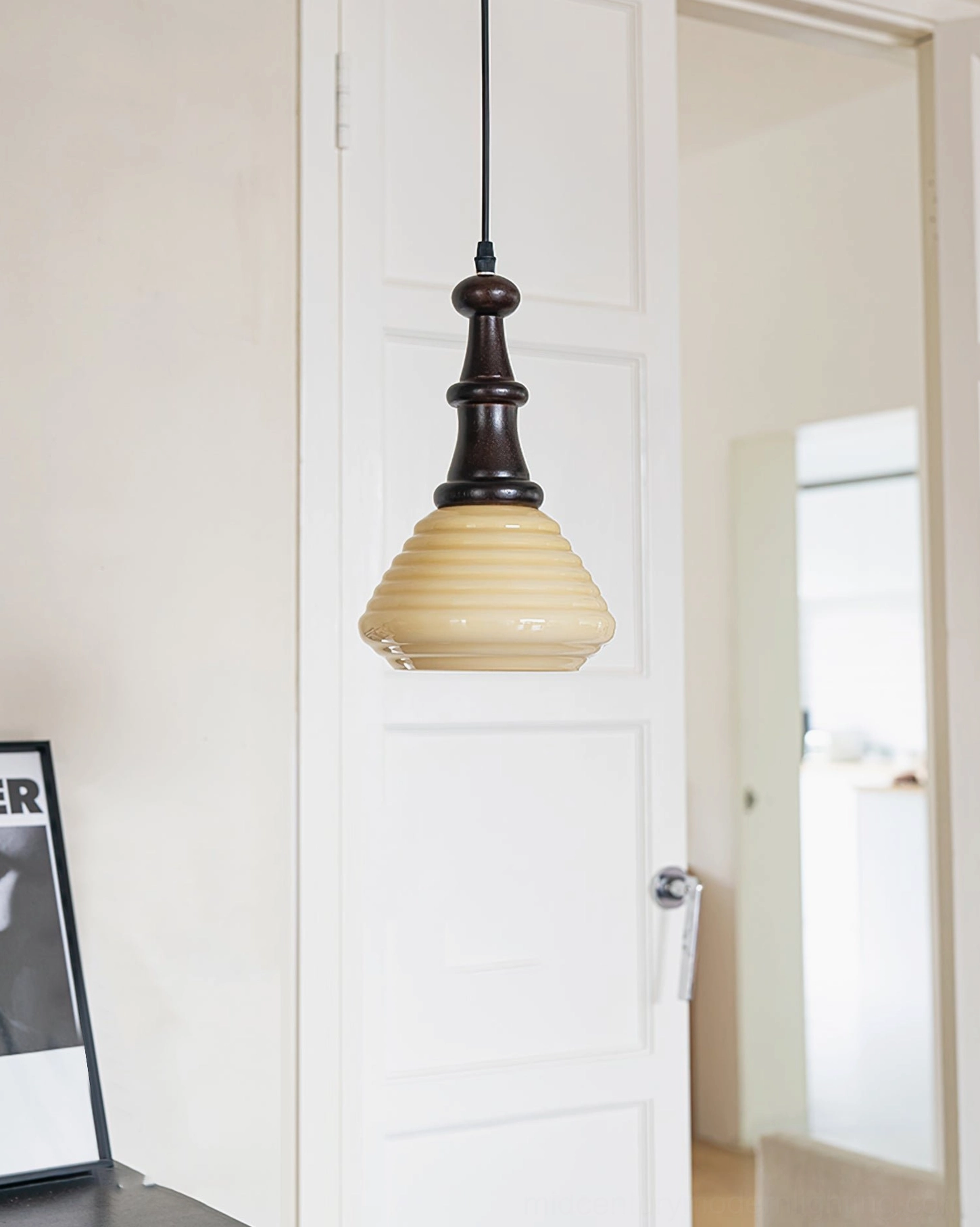 Mid-century modern wooden pendant light in hallway with side table and framed decor showing dark wood finish and design integration