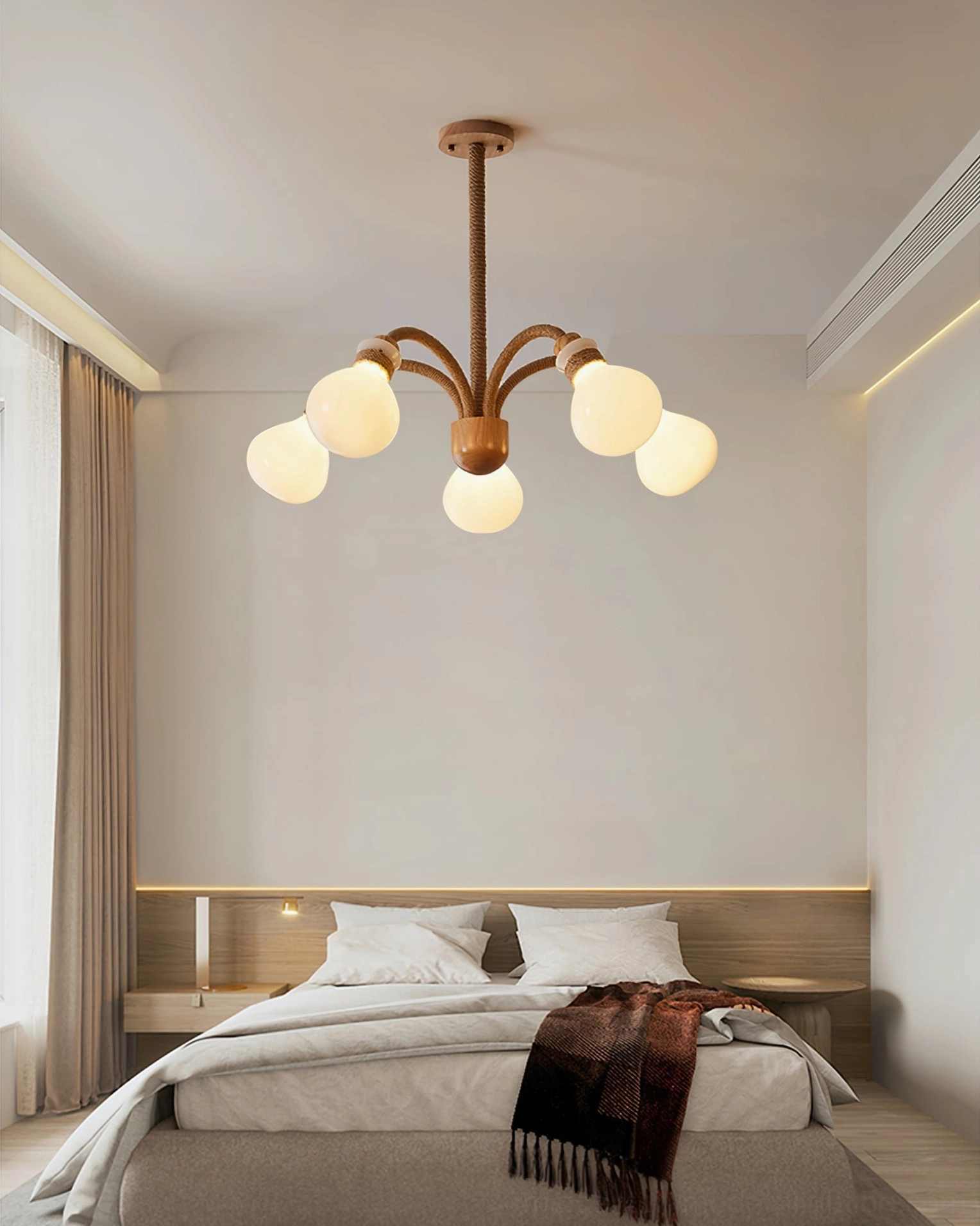 6-light wooden rope chandelier with warm lighting in master bedroom with dark knit throw matching natural wood tone