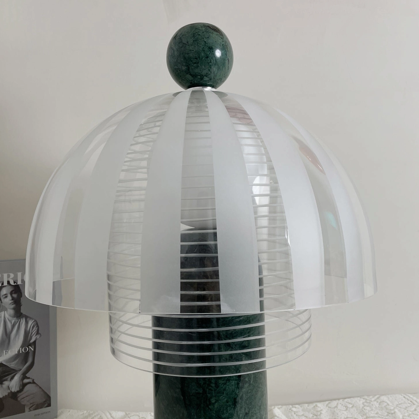 Yasuke table lamp on lace tablecloth desktop, front flat perspective showing marble base and glass dome