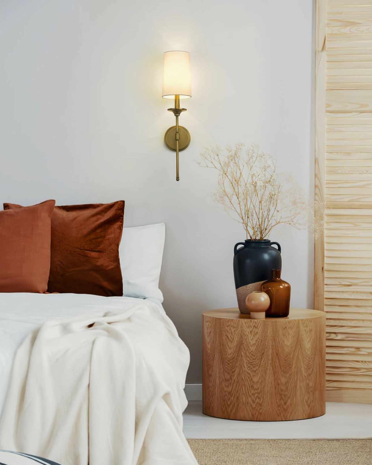 Traditional wall-mounted brass sconce by bedside with warm cozy illumination