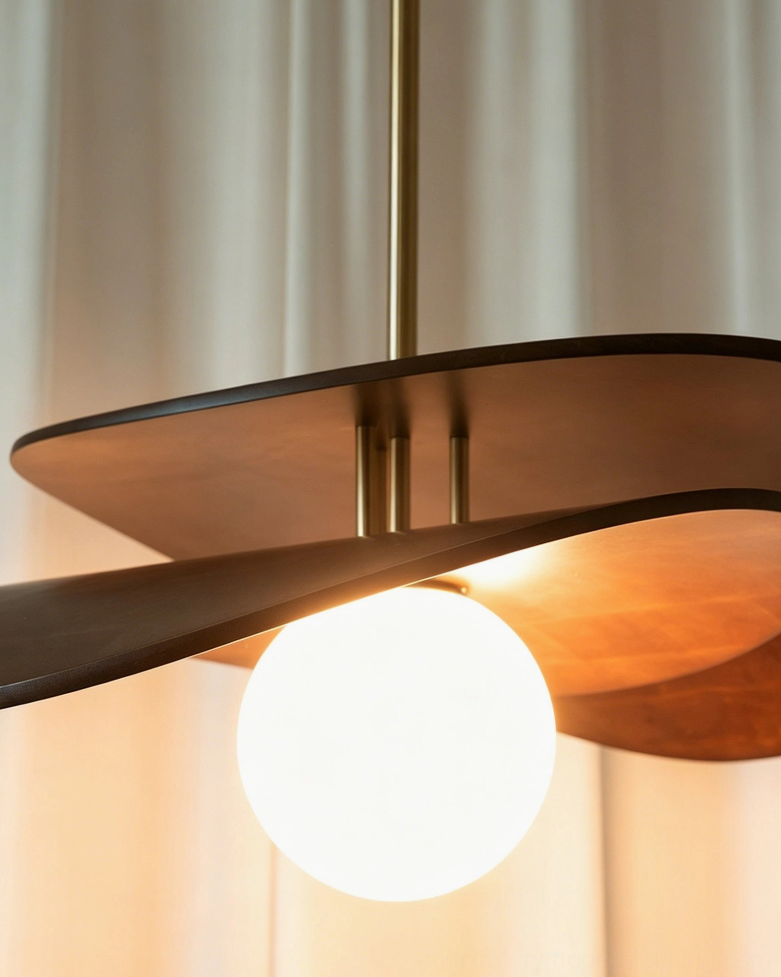 Low-angle close-up of Zane pendant light with glowing opal glass bulb emphasizing hand-blown quality and wood grain texture