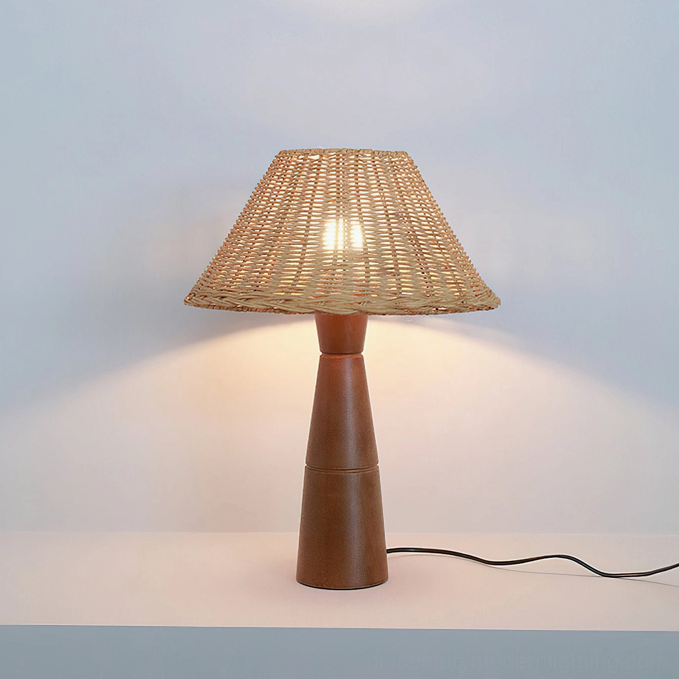 Zaya rattan lamp with Edison bulb showing warm filament light through natural shade, vintage aesthetic