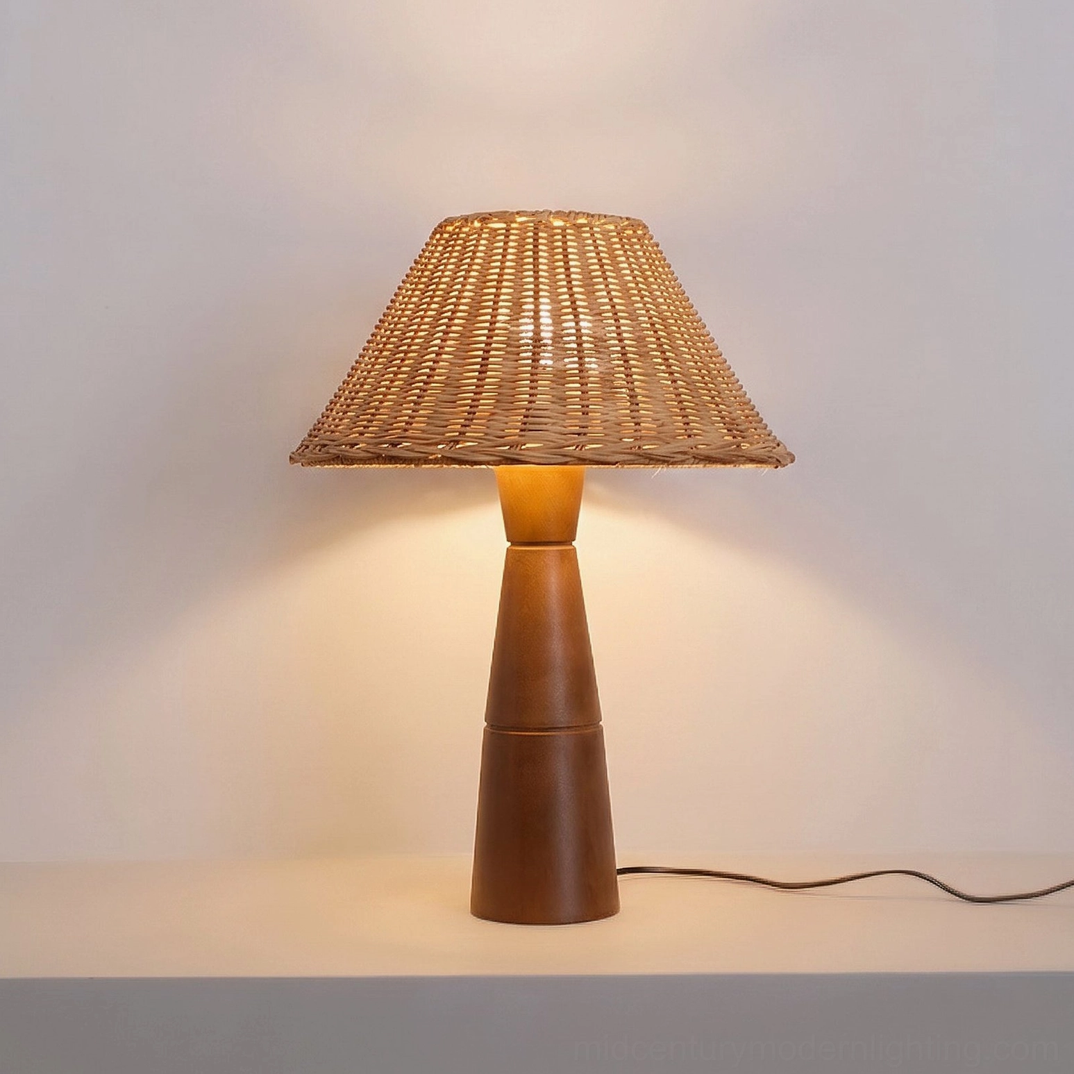 Zaya rattan lamp detail showing walnut base and rattan shade intersection, material contrast view