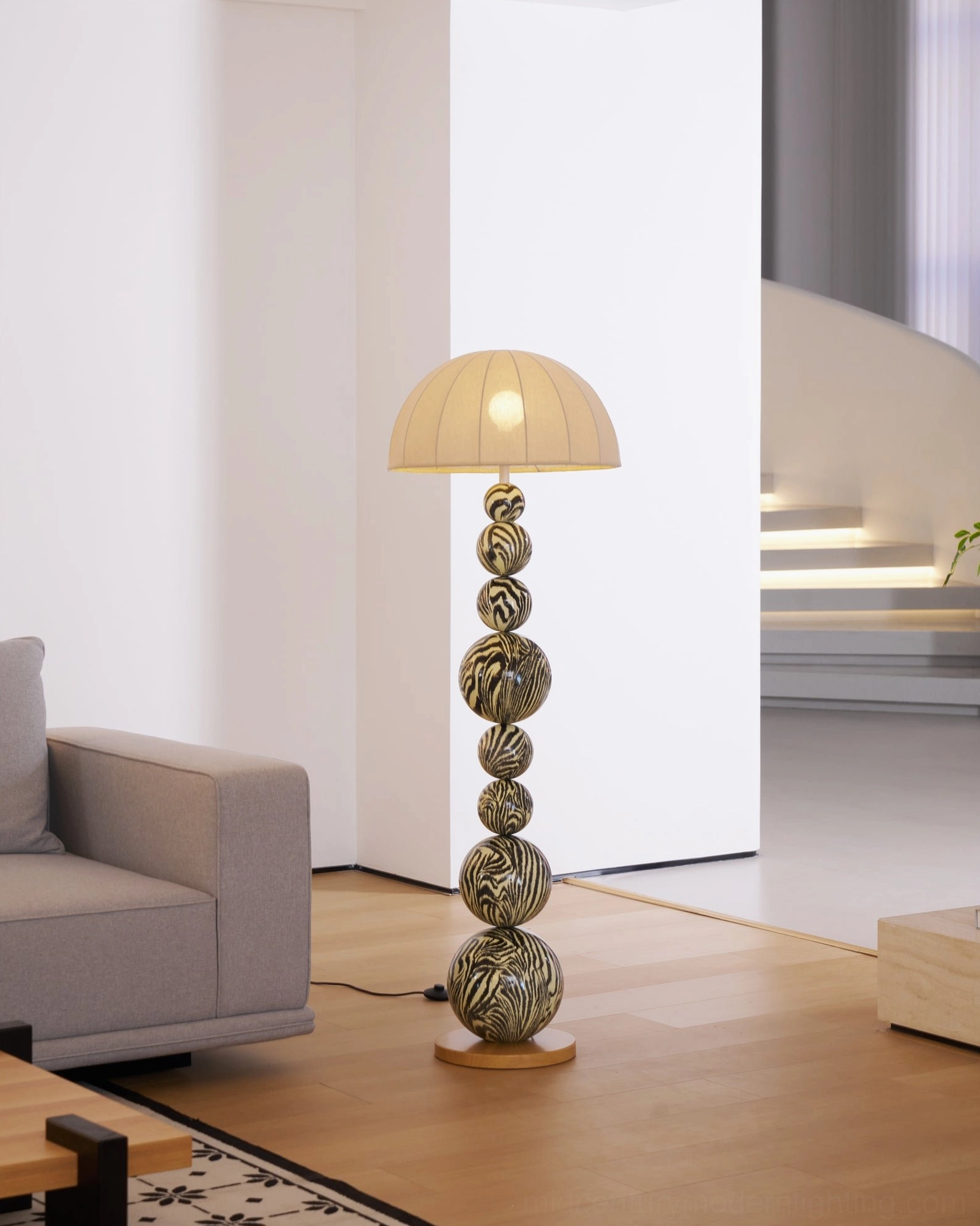 Zebra modern floor lamp in contemporary living room with sofa, illuminated staircase rear view
