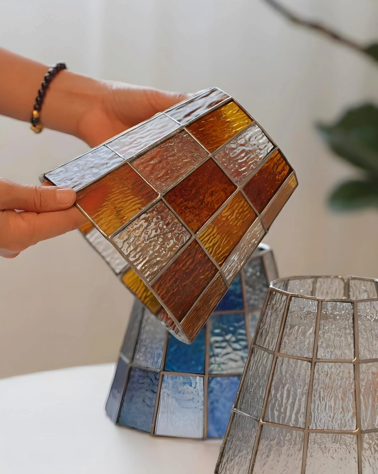 Multiple Zola stained glass pendant lamp shades in amber and blue color options, close-up product detail view
