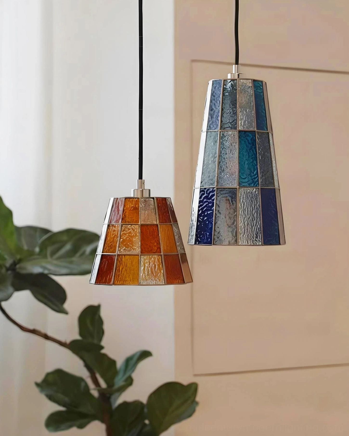 Two Zola stained glass pendant lamps in amber and blue color variants displayed in bright home corner